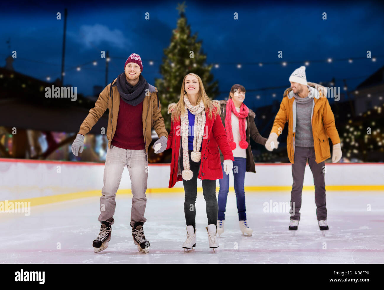 Happy amici sul Natale pista di pattinaggio Foto Stock