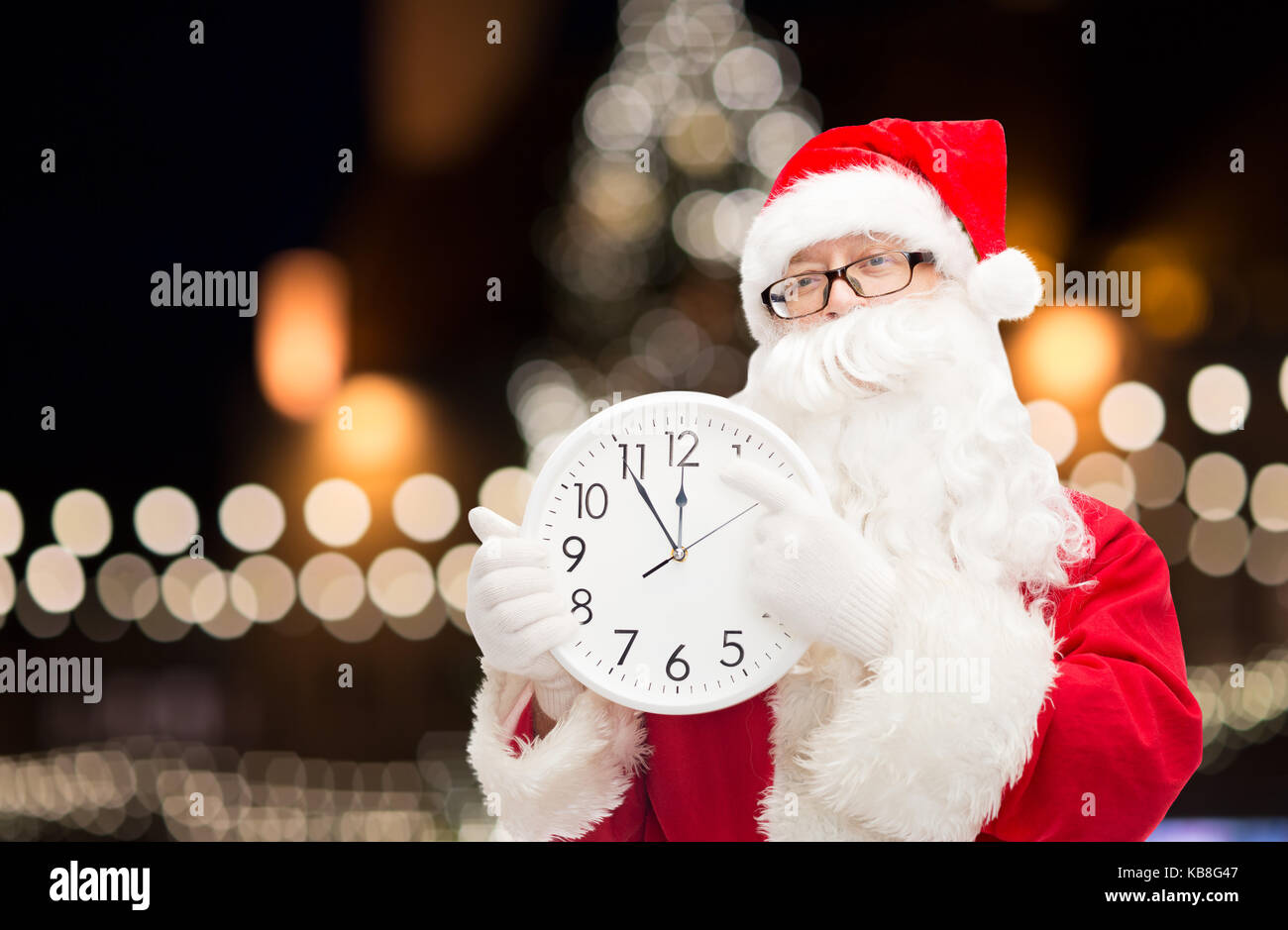 Babbo Natale con orologio puntare il dito a dodici Foto Stock