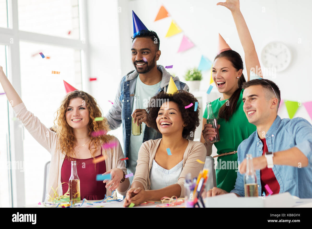 Team contento con i confetti in ufficio festa di compleanno Foto Stock