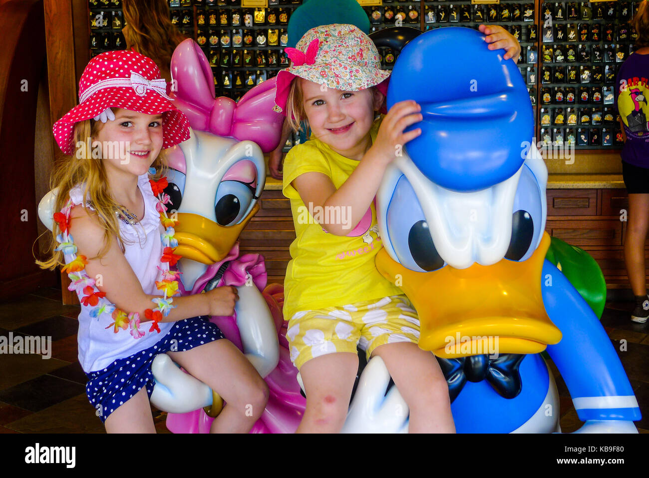 Bambini seduti su un donald e daisy duck life-size statuetta in Disney World, Florida, Stati Uniti d'America Foto Stock