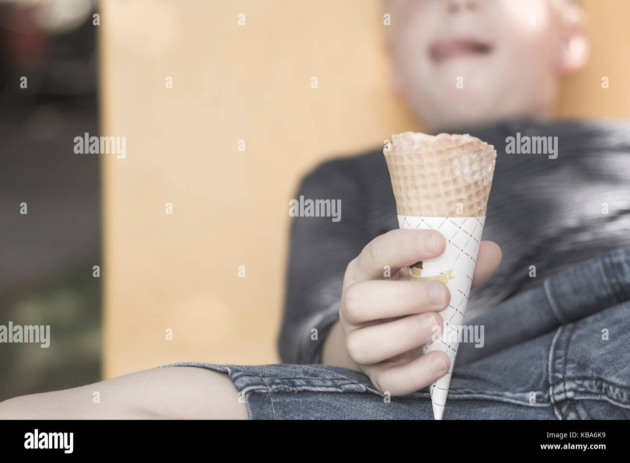 Il ragazzo è un azienda cono gelato, sfondo sfocato Foto Stock