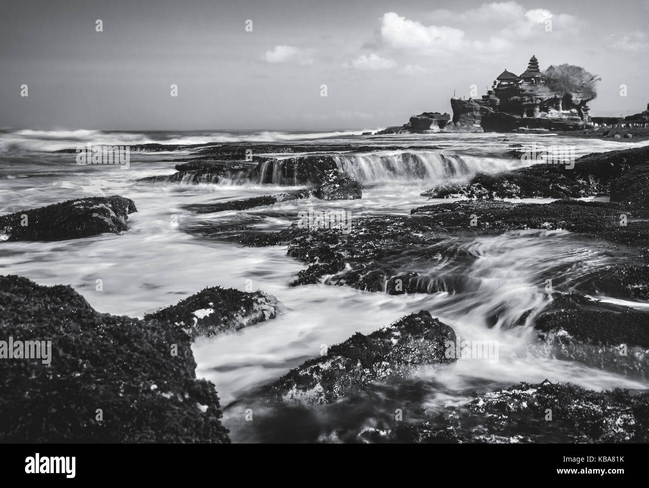 Immagine in bianco e nero di Tanah Lot in Bali. incredibile geologica naturale formazione di roccia con uluwatu temple edificio storico vista da rocce costiere Foto Stock