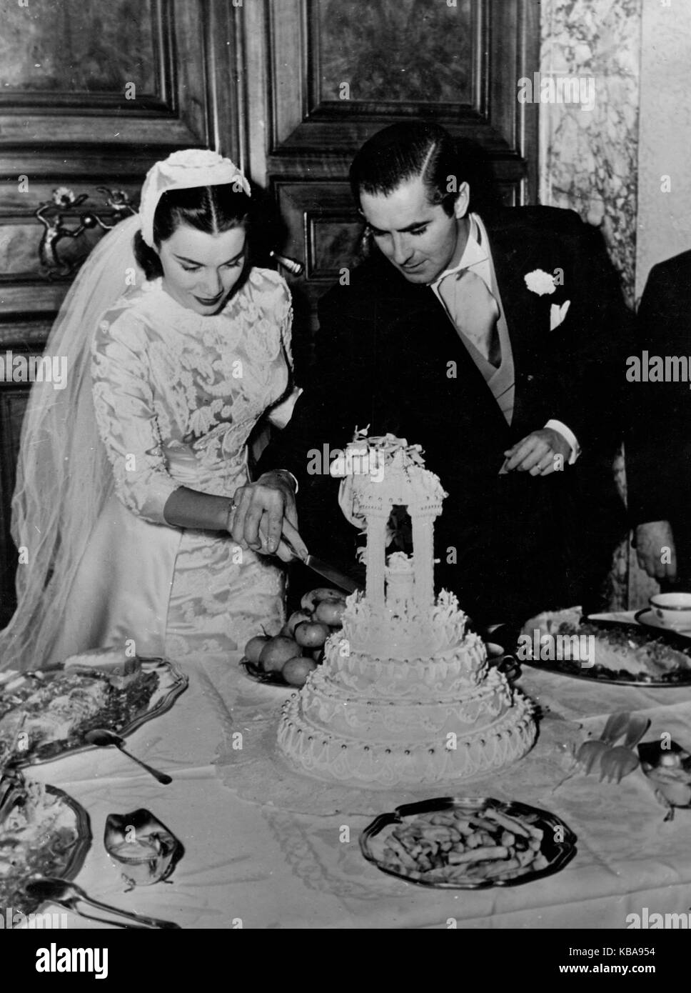 Der amerikanische Schauspieler Tyrone Power schneidet mit circuizione Braut Linda matrice cristiana Hochzeitstorte un, Italien 1940er Jahre. Attore americano Tyrone Power e la sua sposa Linda cristiani condividono la torta di nozze, Italia 1940s. Foto Stock