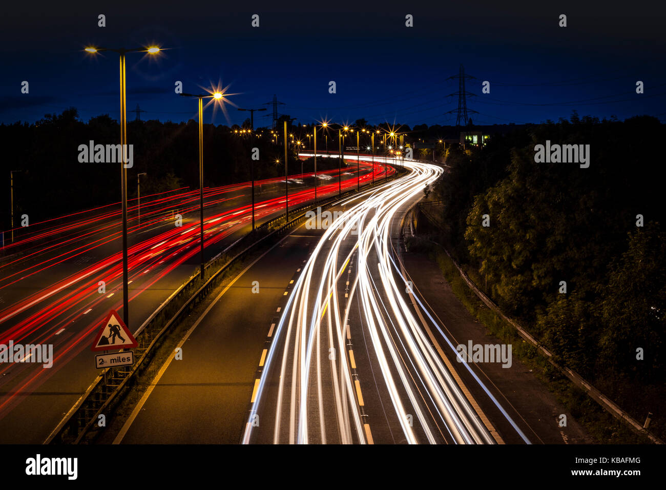 Prese a tarda sera oltre il ponte autostradale. motion blur di fari e luci di posizione posteriori Foto Stock