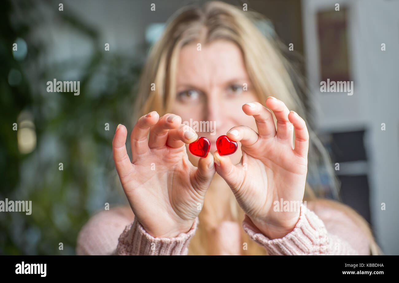 In prossimità di una donna di mani tenendo un cuore rosso Foto Stock