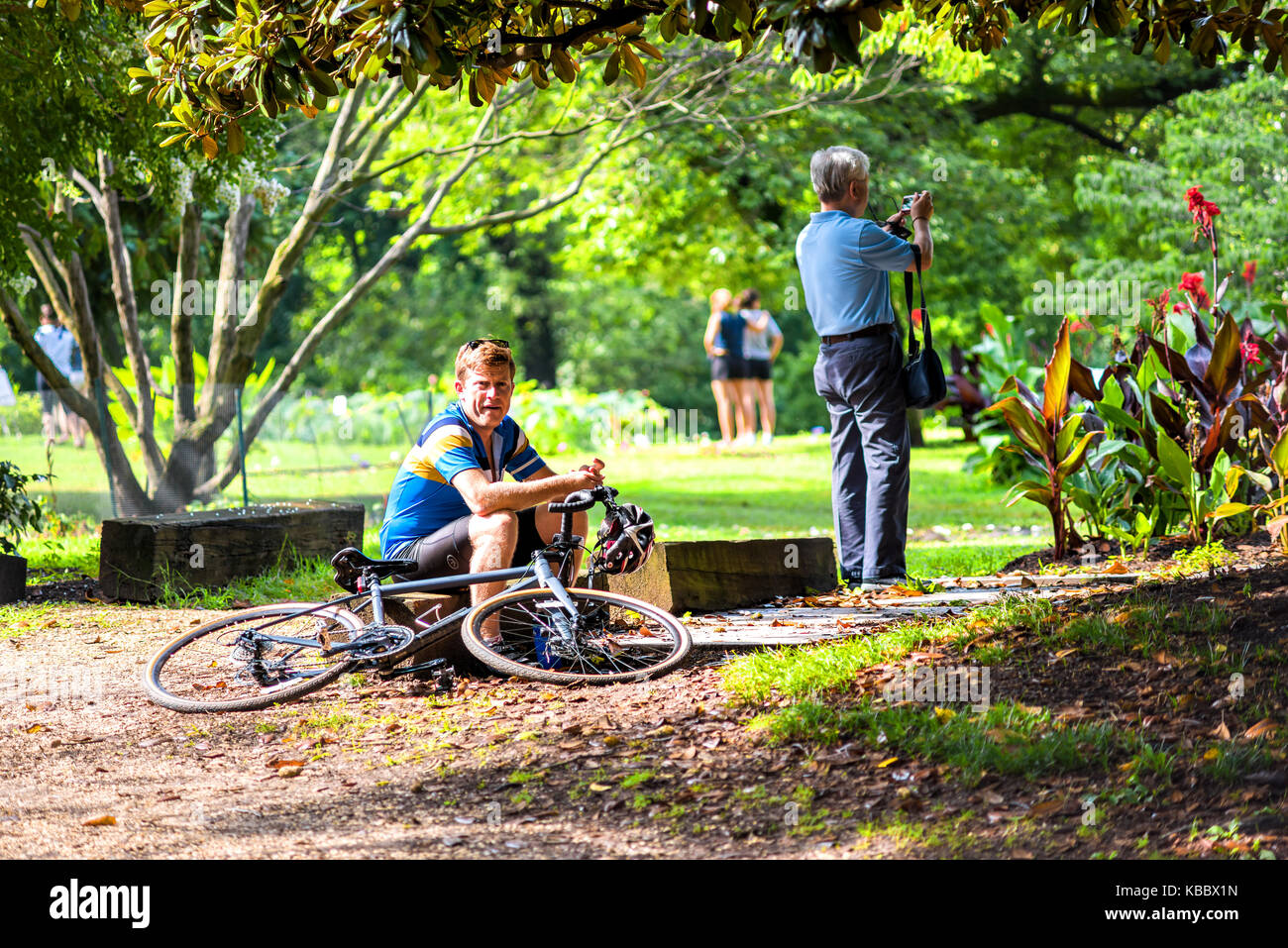 Washington DC, Stati Uniti d'America - Luglio 23, 2017: turisti gente e l'uomo con la bicicletta, ciclista, ciclista seduto a Kenilworth giardini acquatici durante il fiore di loto Foto Stock