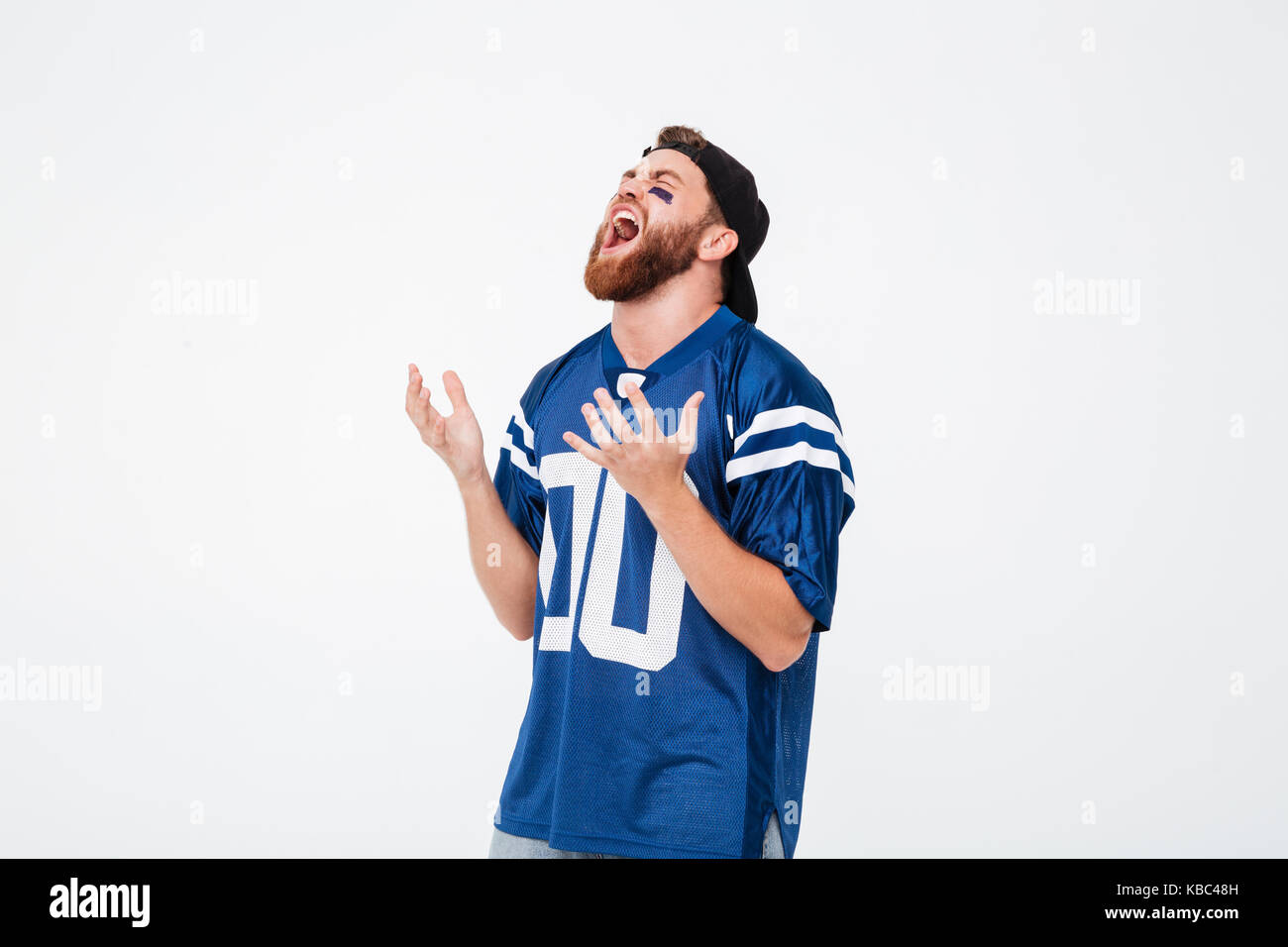Triste urlando emotional man ventola in blu t-shirt in piedi isolato su sfondo bianco. Guardando a parte. Foto Stock