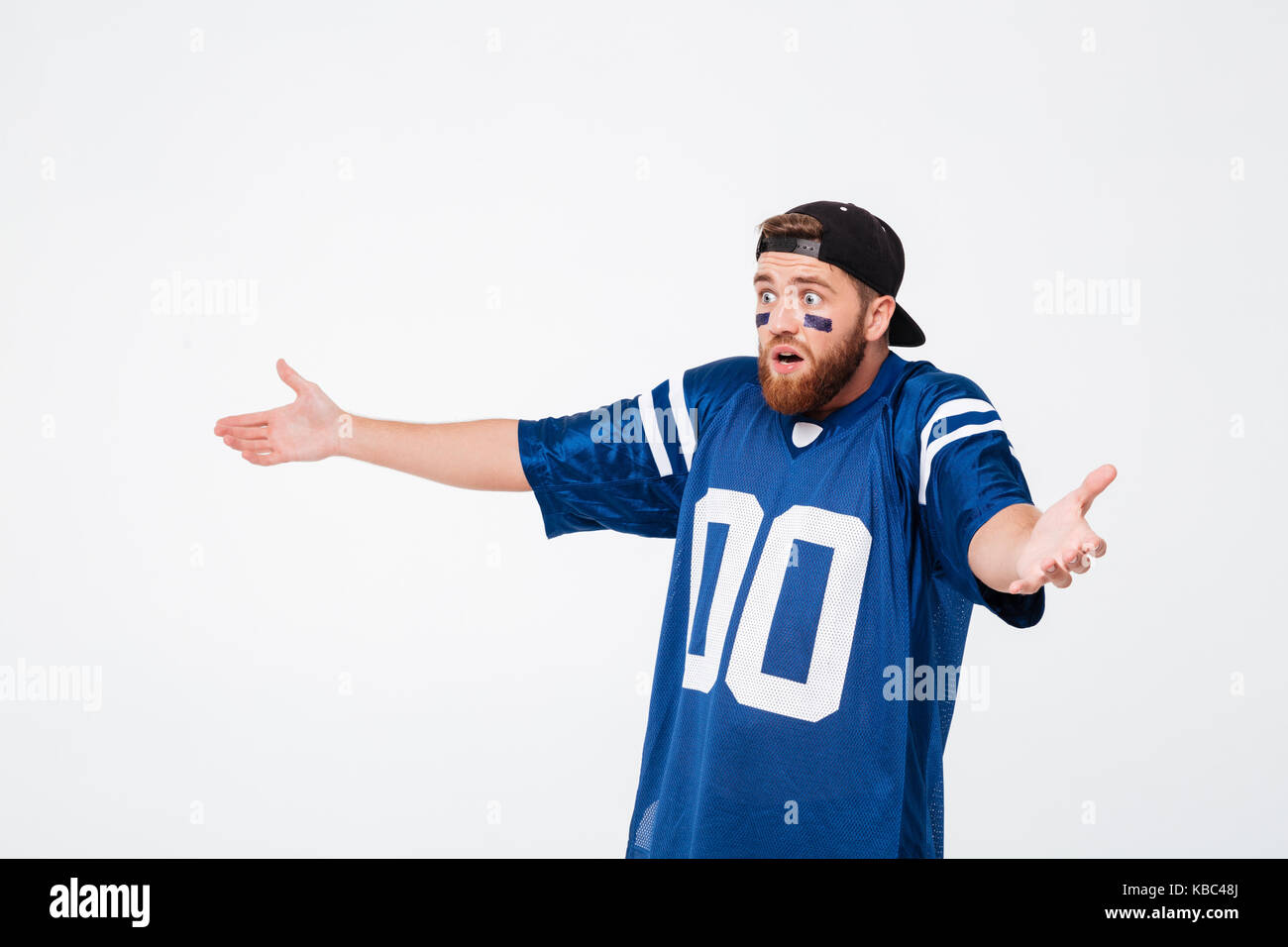 Triste urlando emotional man ventola in blu t-shirt in piedi isolato su sfondo bianco. Guardando a parte. Foto Stock