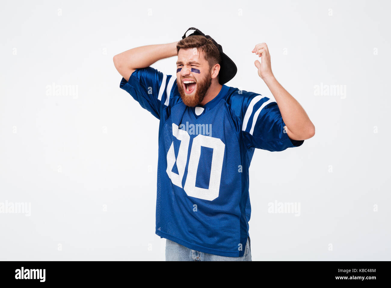 Triste urlando emotional man ventola in blu t-shirt in piedi isolato su sfondo bianco. Guardando a parte. Foto Stock