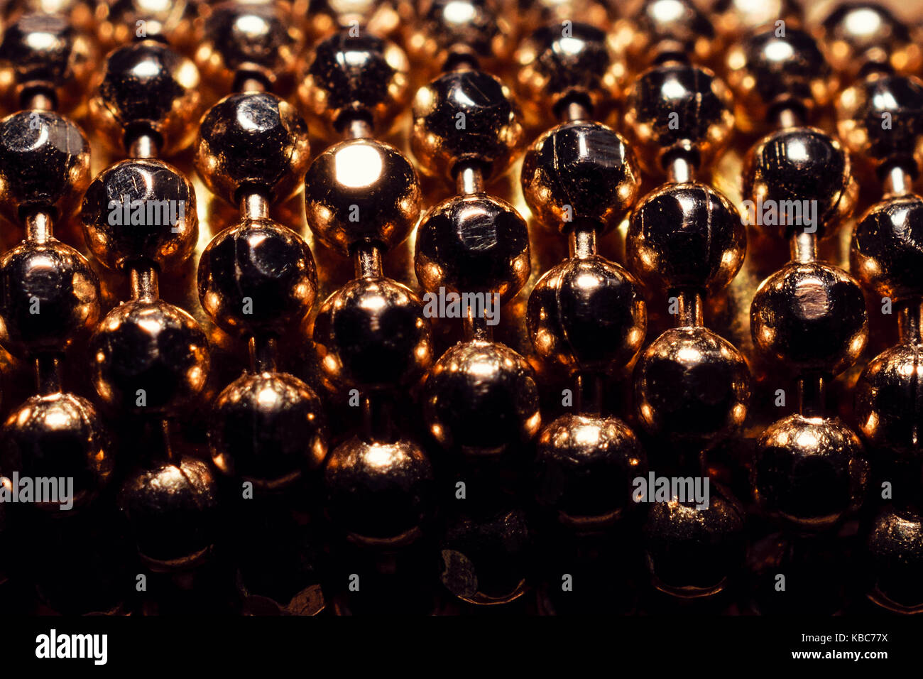 Extreme close-up di sfere d'oro dal bracciale Foto Stock