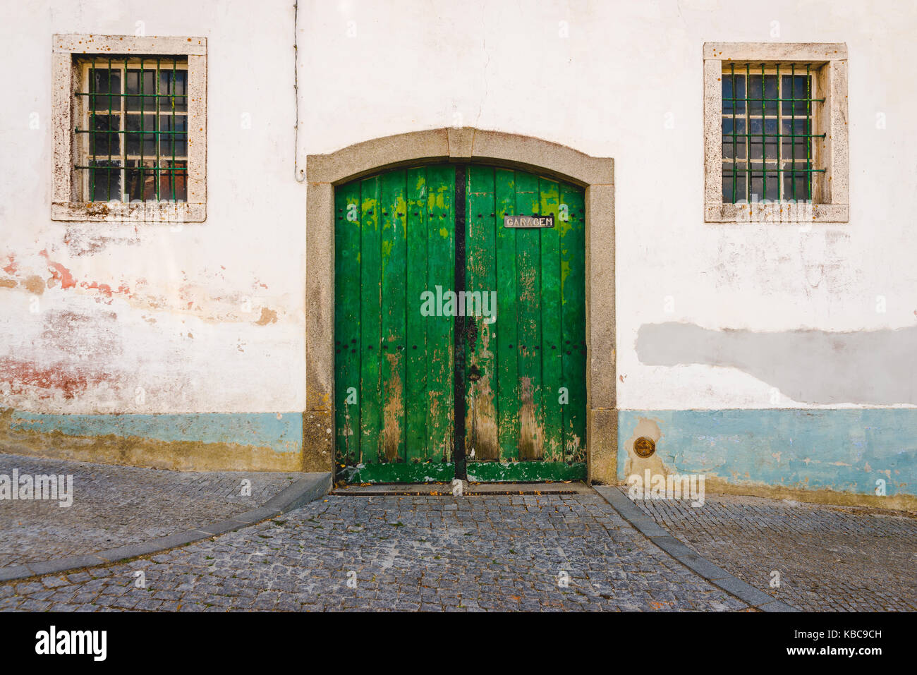 Vecchio garage porta verde e due finestre Foto Stock