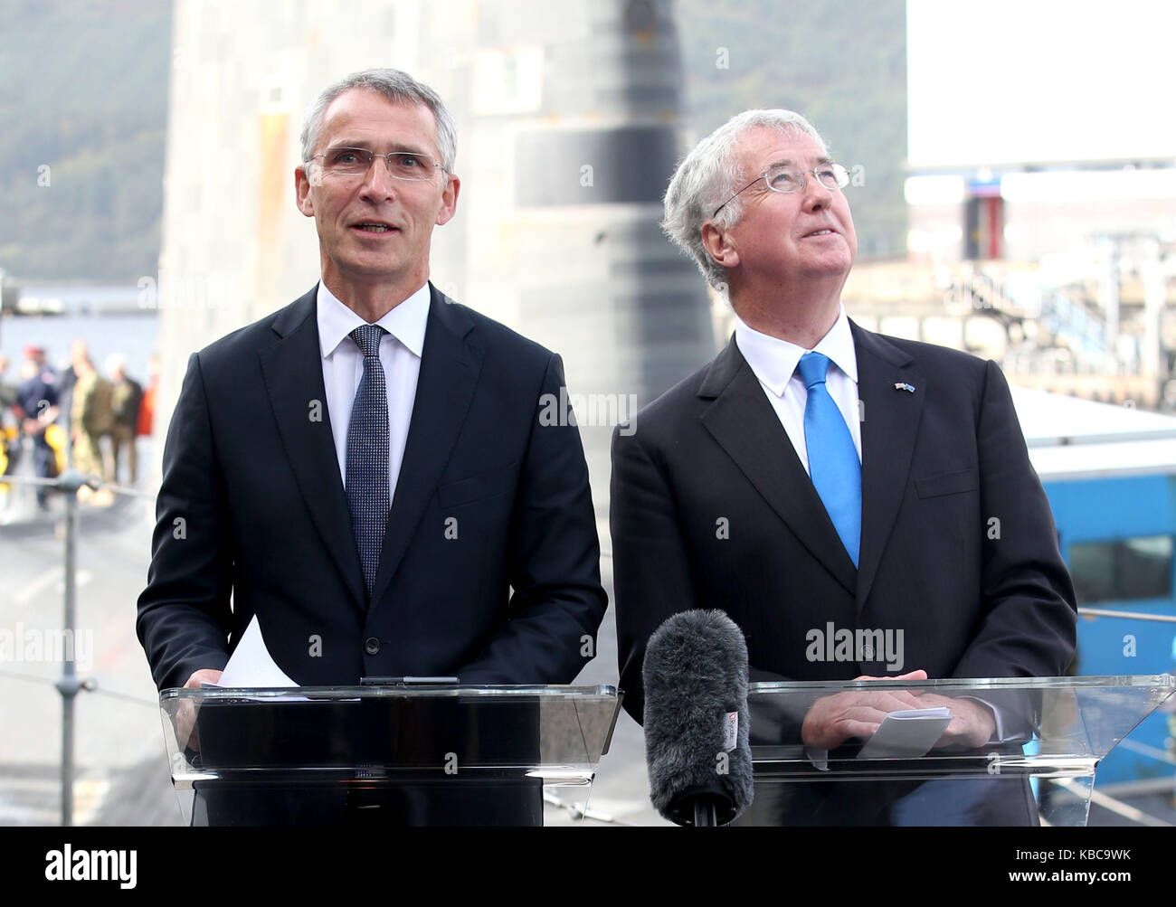 Il segretario alla difesa di sir michael fallon (a destra) e il segretario generale della NATO jens stollenberg (sinistra) parlare con i media a fianco della Vanguard-classe deterrente nucleare sommergibile hms vendetta durante una visita alla hm base navale clyde, faslane, dove i negoziati bilaterali sulla collettiva di sicurezza globale sono state detenute. Foto Stock