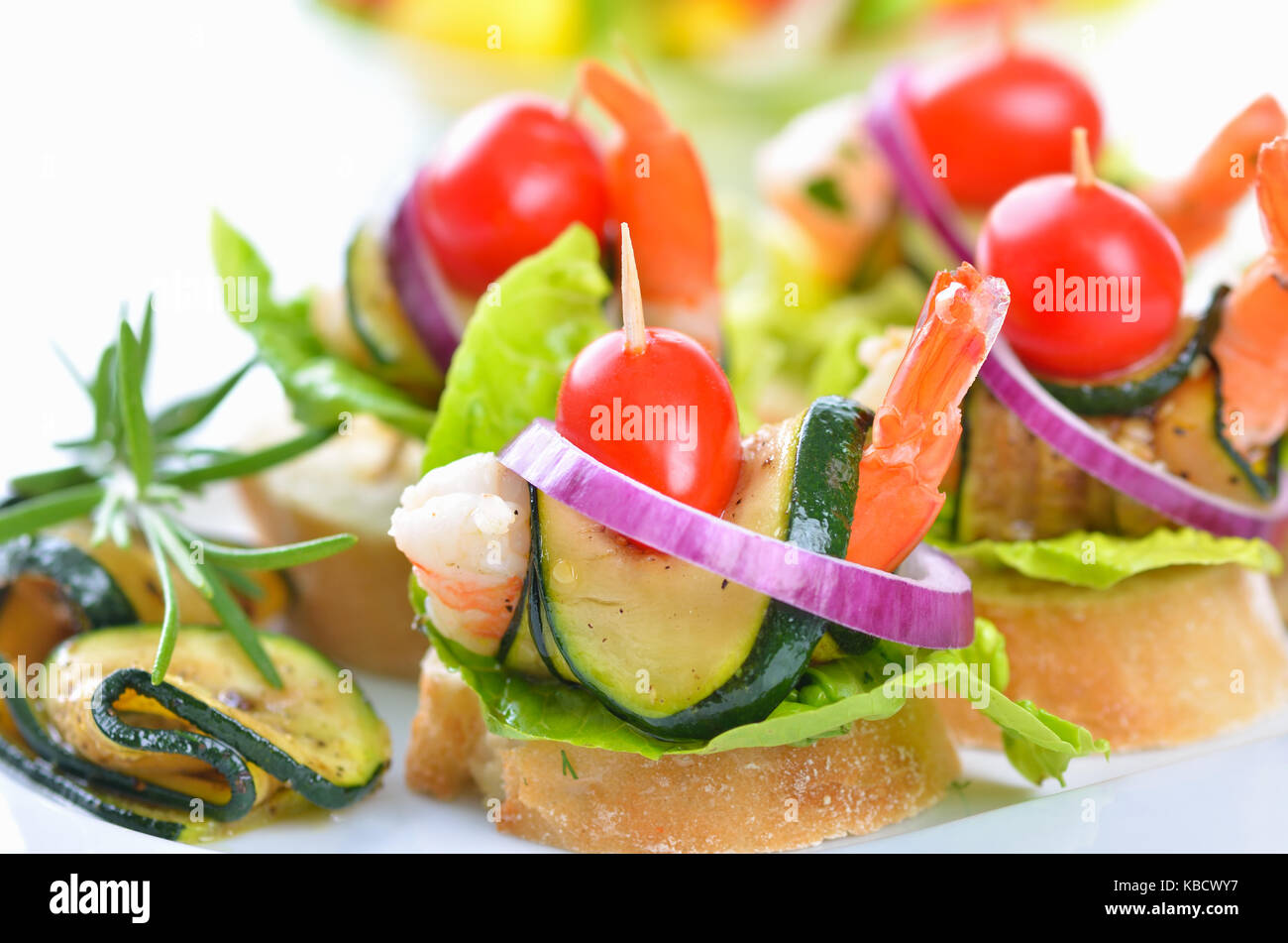Scampi spiedini con zucchine fritte sul pane italiano Foto Stock