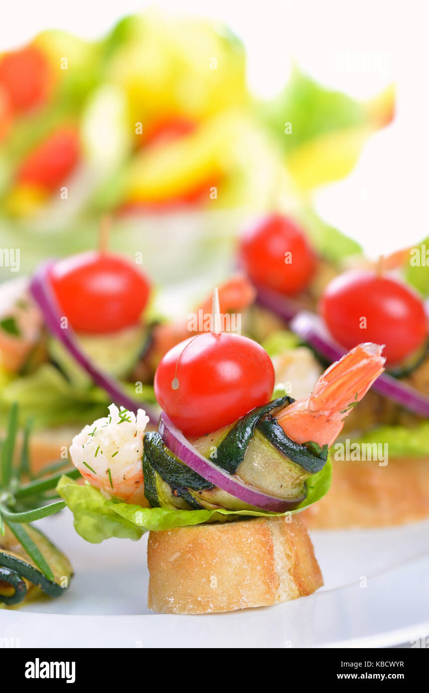 Scampi spiedini con zucchine fritte sul pane italiano Foto Stock