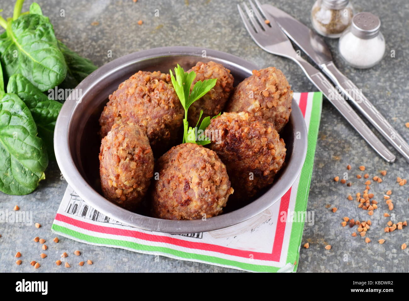 Polpette con grano saraceno in una ciotola di metallo su un grigio Sfondo astratto.il cibo sano.mangiare sano concetto Foto Stock