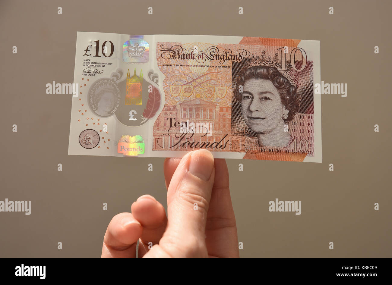 Close up di senior lady tenendo il nuovo polimero dieci sterling pound nota Foto Stock