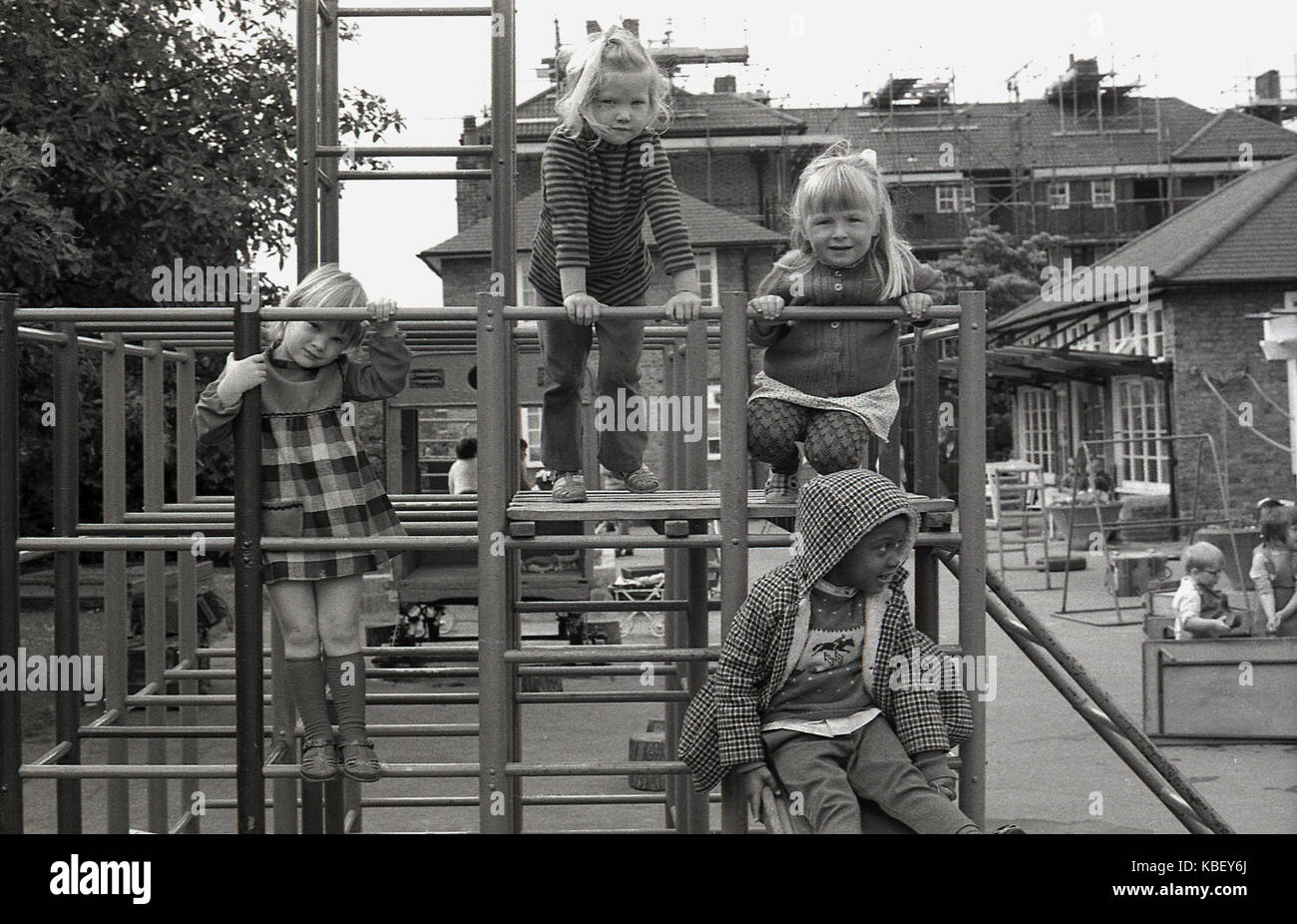 Anni Settanta, storiche, i bambini su una scalata al di fuori del telaio in corrispondenza di una faccia interna-london nursery su un alloggiamento del consiglio estate in Deptford, Londra Sud, Englad, UK. Foto Stock