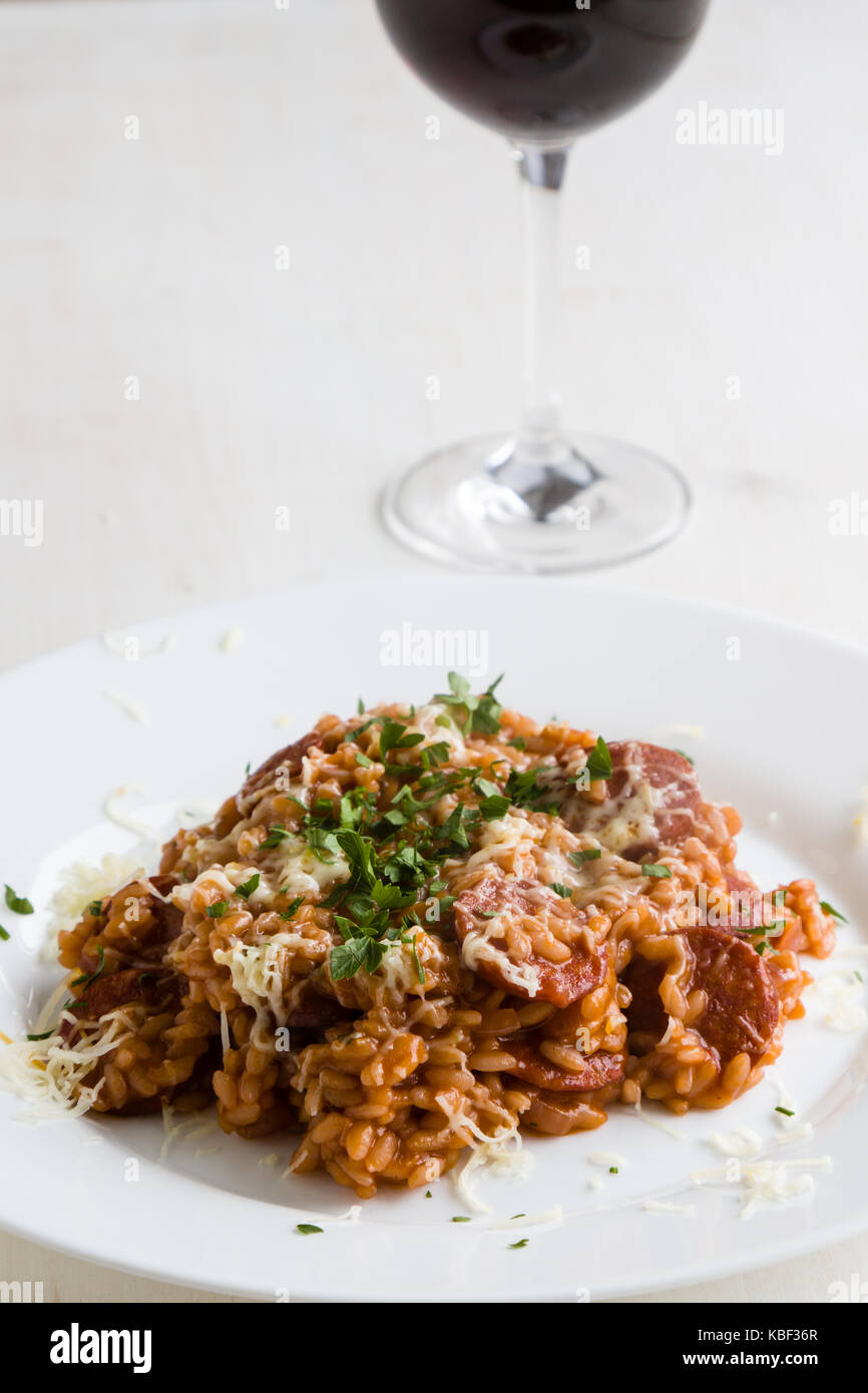 Il chorizo risotto con pomodoro e vino rosso sulla piastra bianca Foto Stock