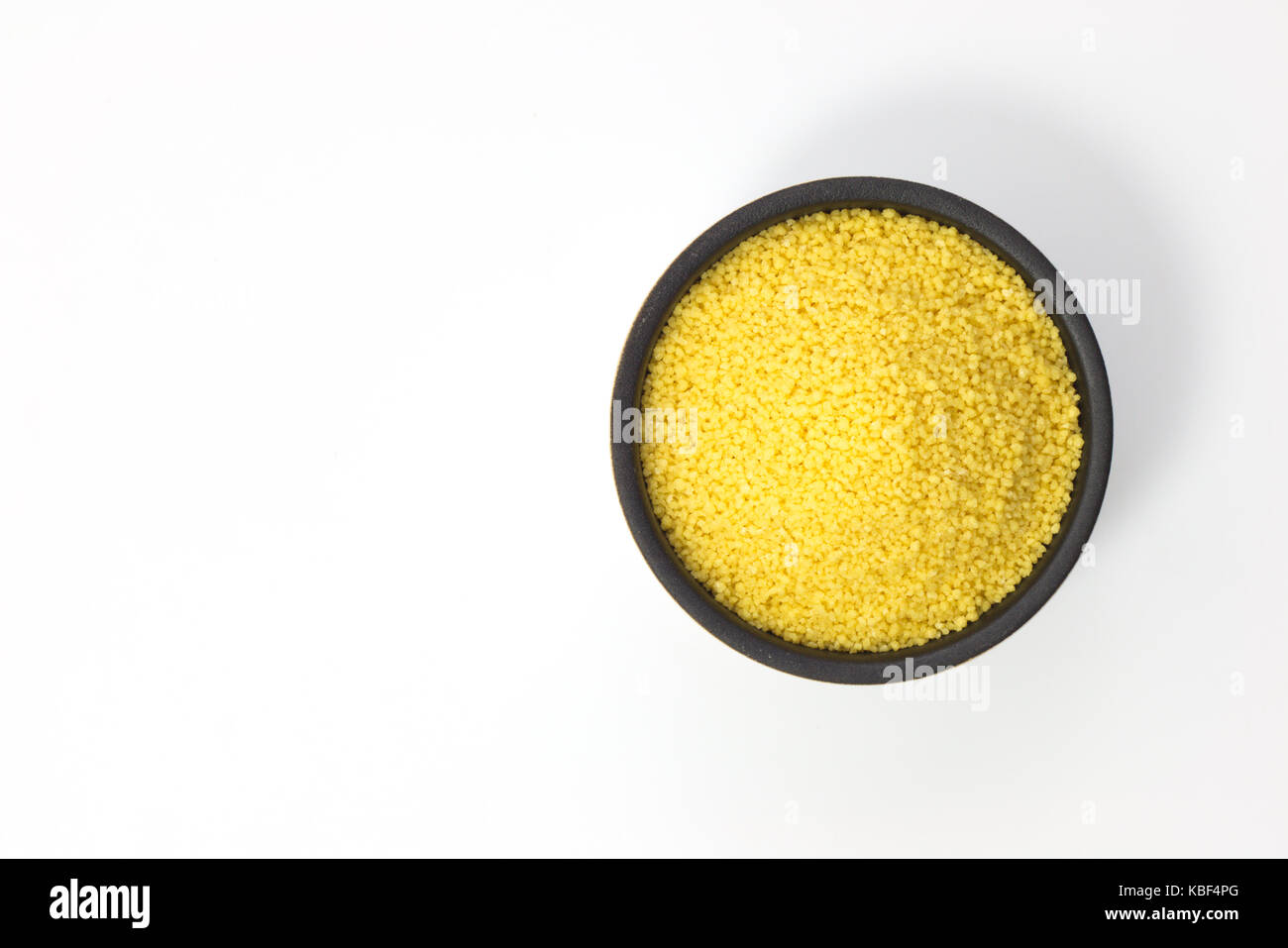 Concetto di cibo crudo couscous organico in un recipiente su sfondo bianco con spazio di copia Foto Stock