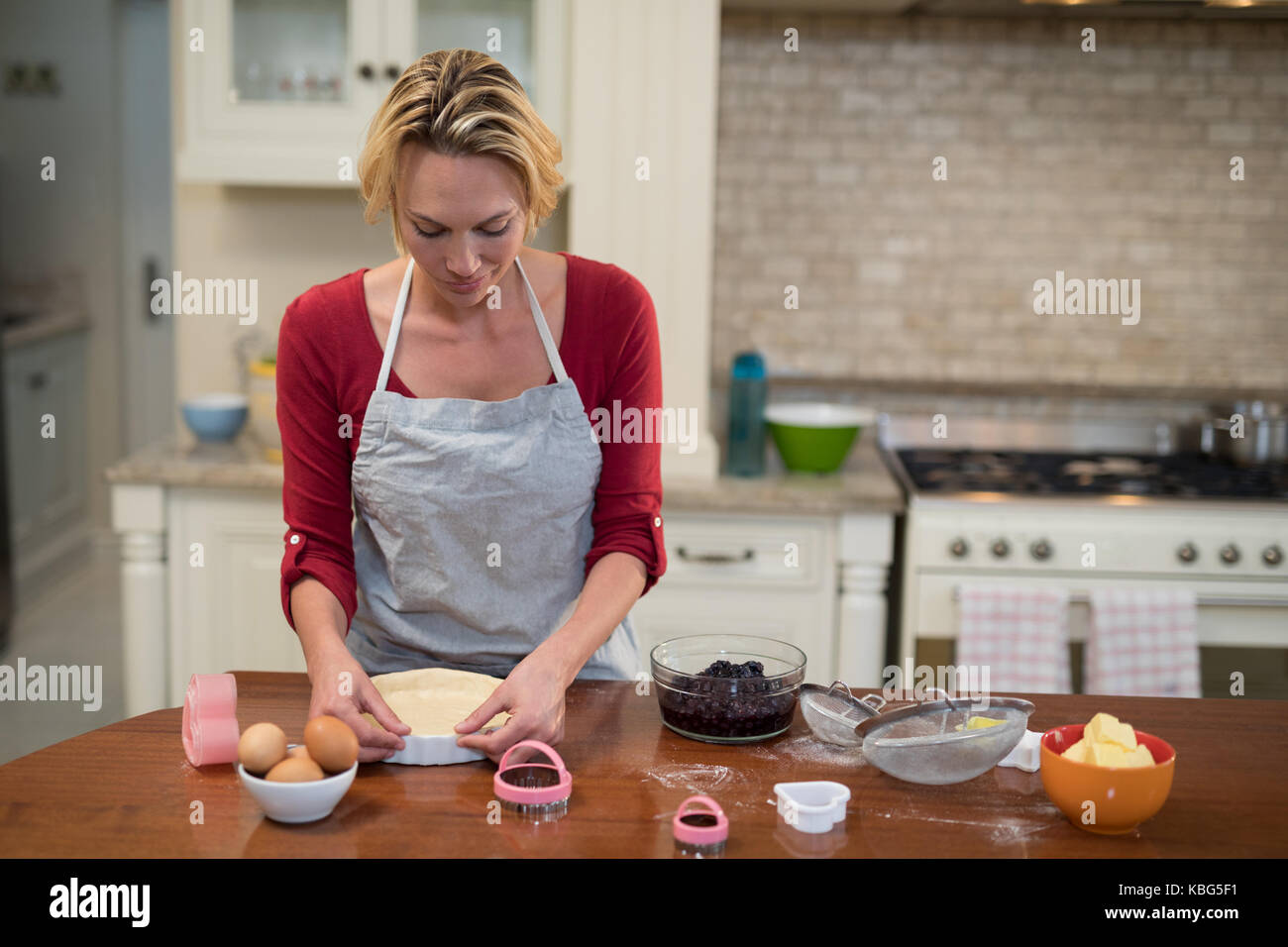 Donna preparazione pan torta in cucina a casa Foto Stock