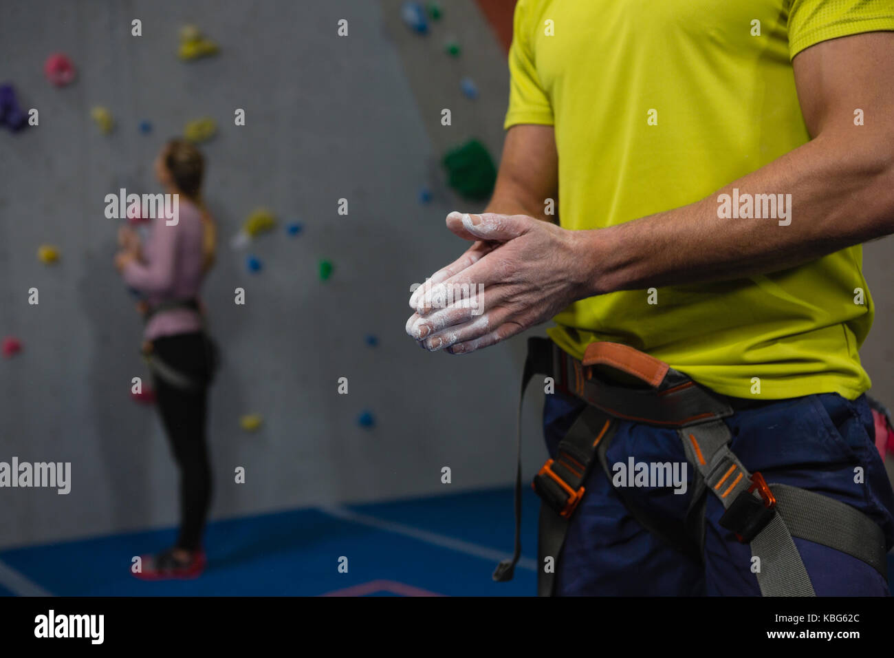 Sezione mediana di atleta maschio applicando polvere di gesso a mani nel club salute Foto Stock