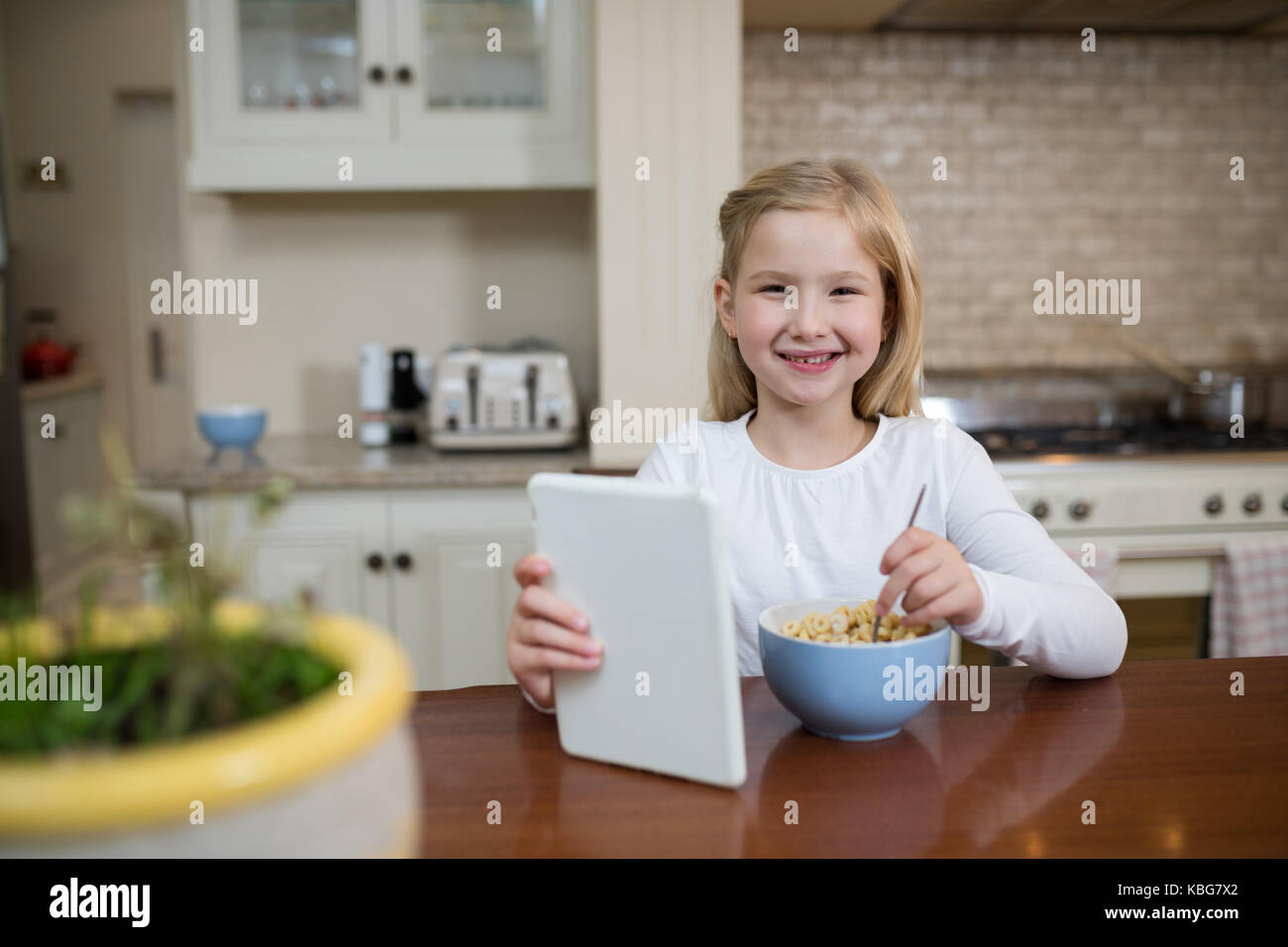 Ritratto di giovane ragazza avente la colazione nella cucina di casa Foto Stock