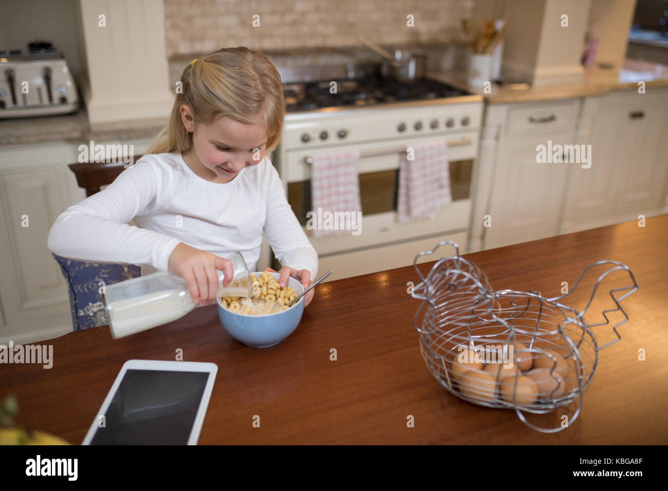 Ritratto di giovane ragazza avente la colazione nella cucina di casa Foto Stock