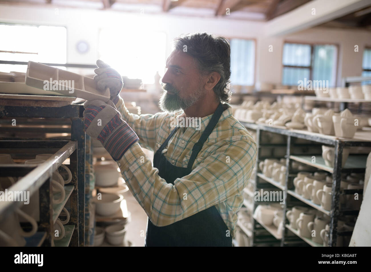Potter maschio immissione prodotto artigianale sul ripiano in laboratorio di ceramica Foto Stock