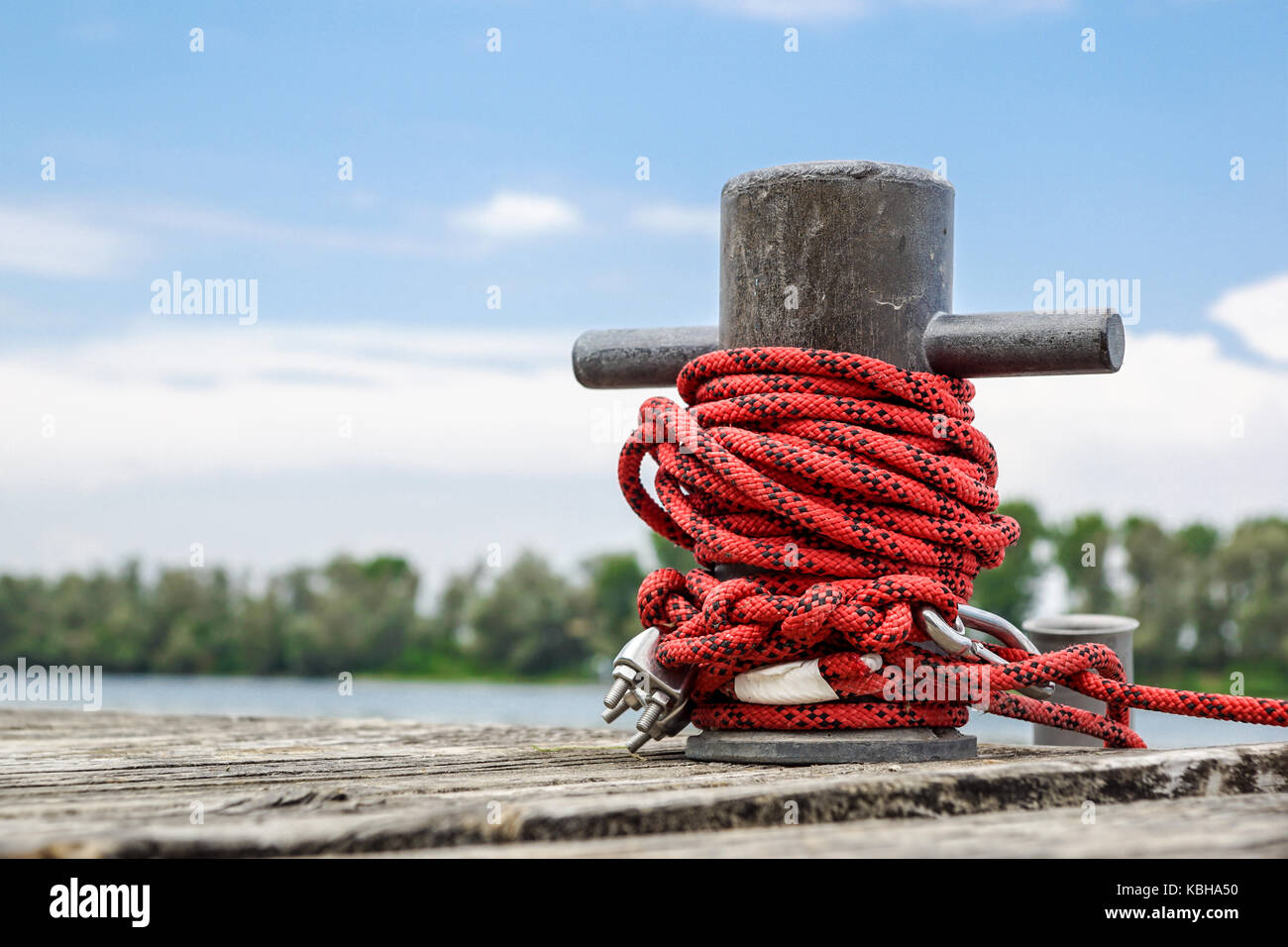 Indossato il vecchio arrugginito bollard ormeggio con funi pesanti sul ponte di una nave, primo piano. Foto Stock