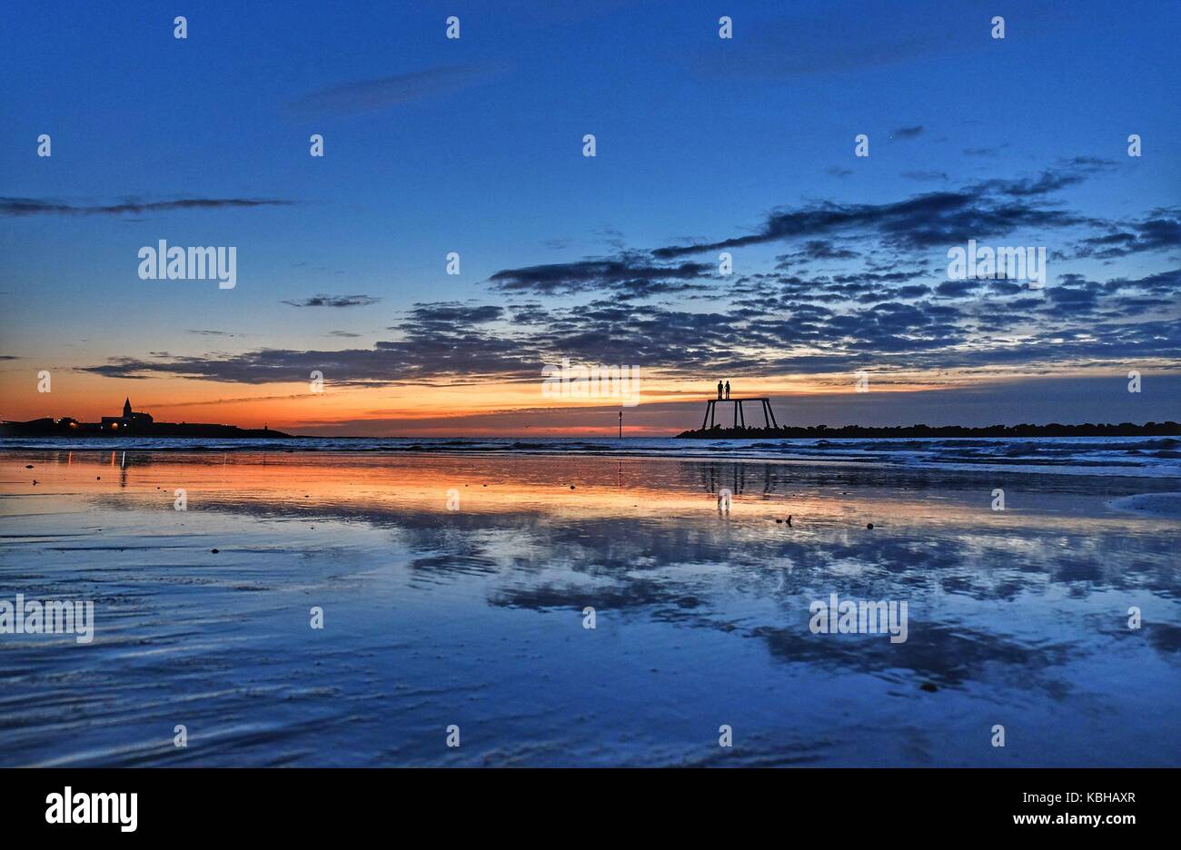Il sole autunnale sorge sul mare nord di fronte alla coppia dell'artista Sean Henry a Newbiggin-by-the-Sea, Northumberland, come la Gran Bretagna è sulla rotta per la pioggia pesante e gales come resti dell'uragano Lee aggiungere l'oomph supplementare ad un sistema di bassa pressione che si muove attraverso l'Atlantico, ha detto i previsori. Foto Stock