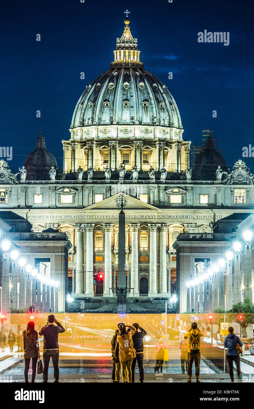Vista illuminata Basilica di San Pietro, Via della Conciliazione e sentieri di luce delle vetture in Roma, Italia Foto Stock