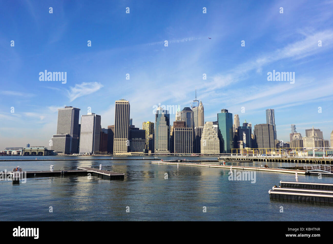 Skyline di New York da Brooklyn lato del fiume Hudson, mezzogiorno cielo blu e lisciato nuvole Inverno tempo Foto Stock