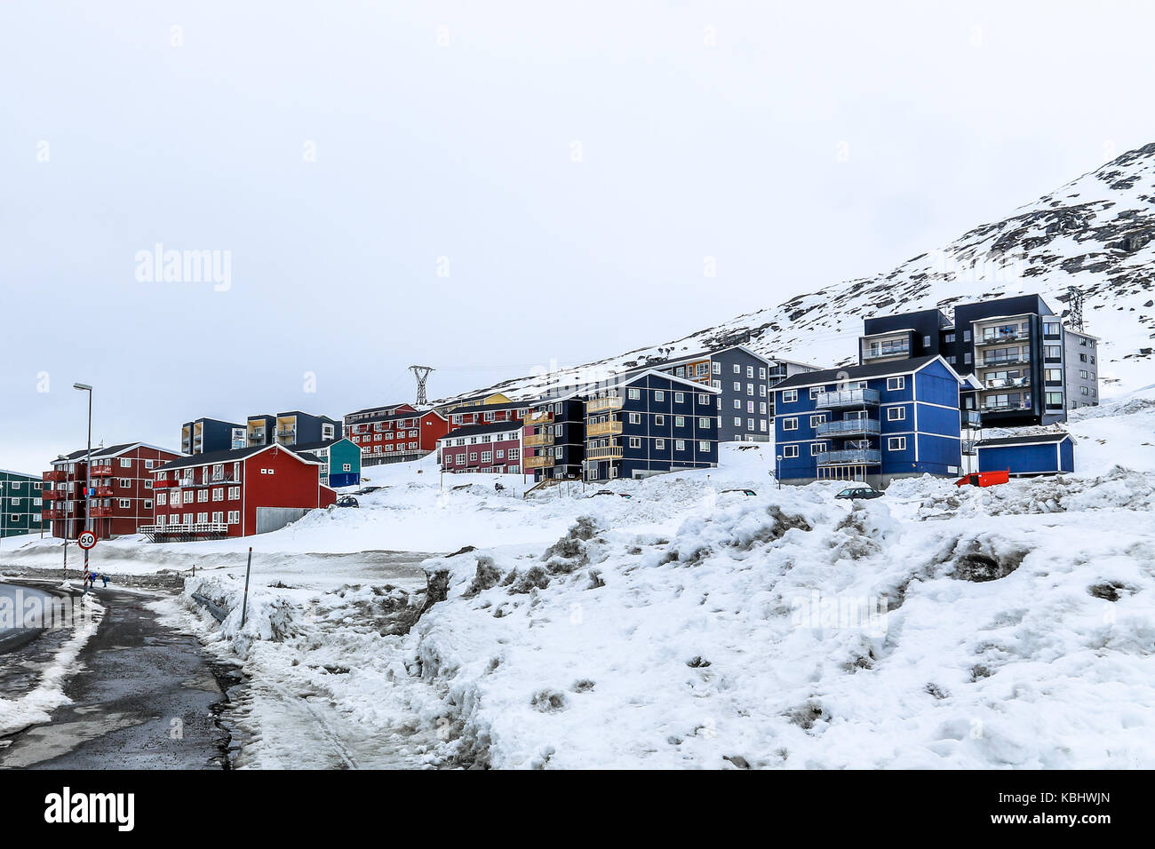 Inverno street e la fila di colorate case inuit sul pendio della montagna di neve in Nuuk, Groenlandia Foto Stock