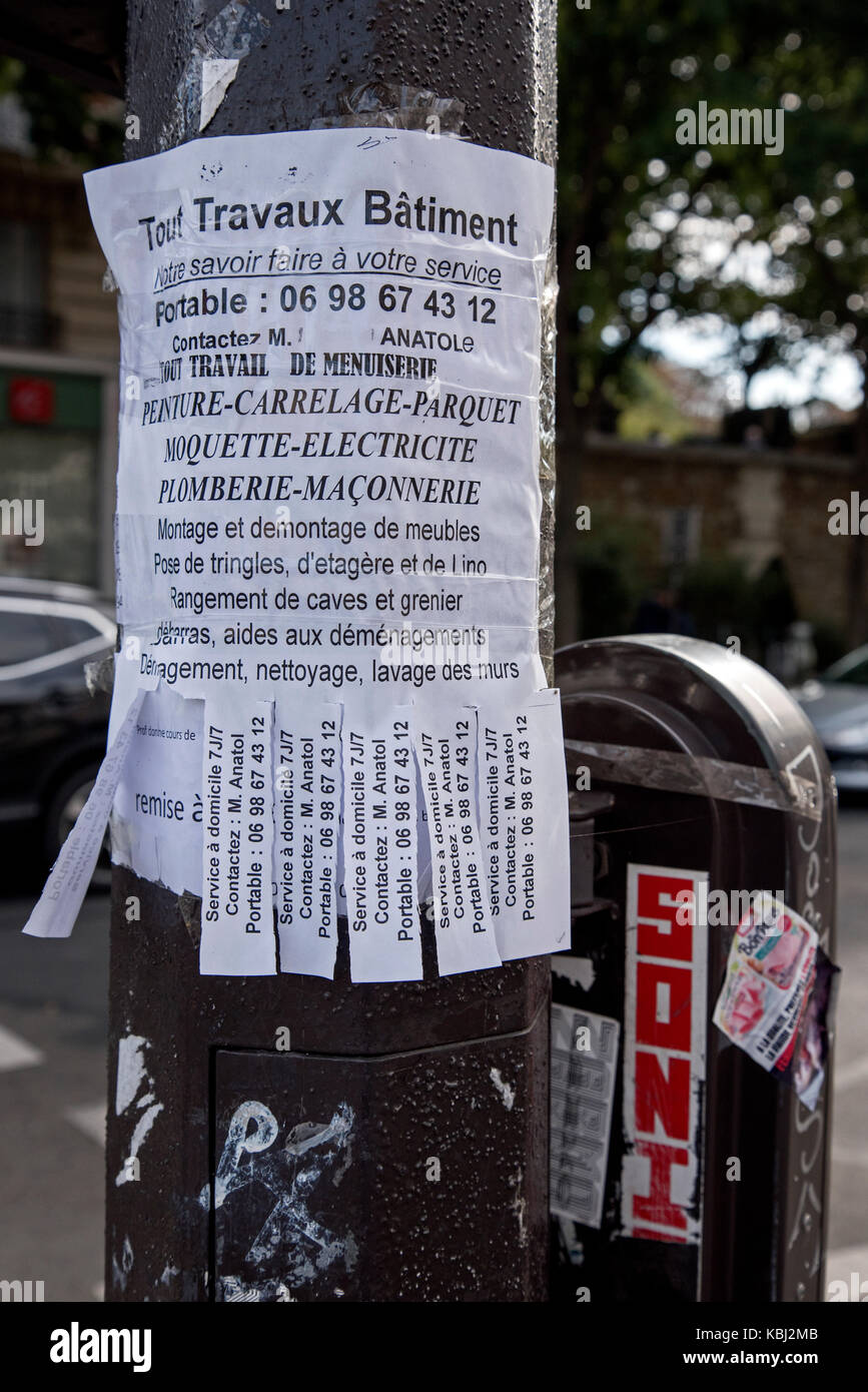 Poster fatti a mano con lo strappo numero di telefono listelli sul Boulevard de Ménilmontant a Parigi la pubblicità Foto Stock