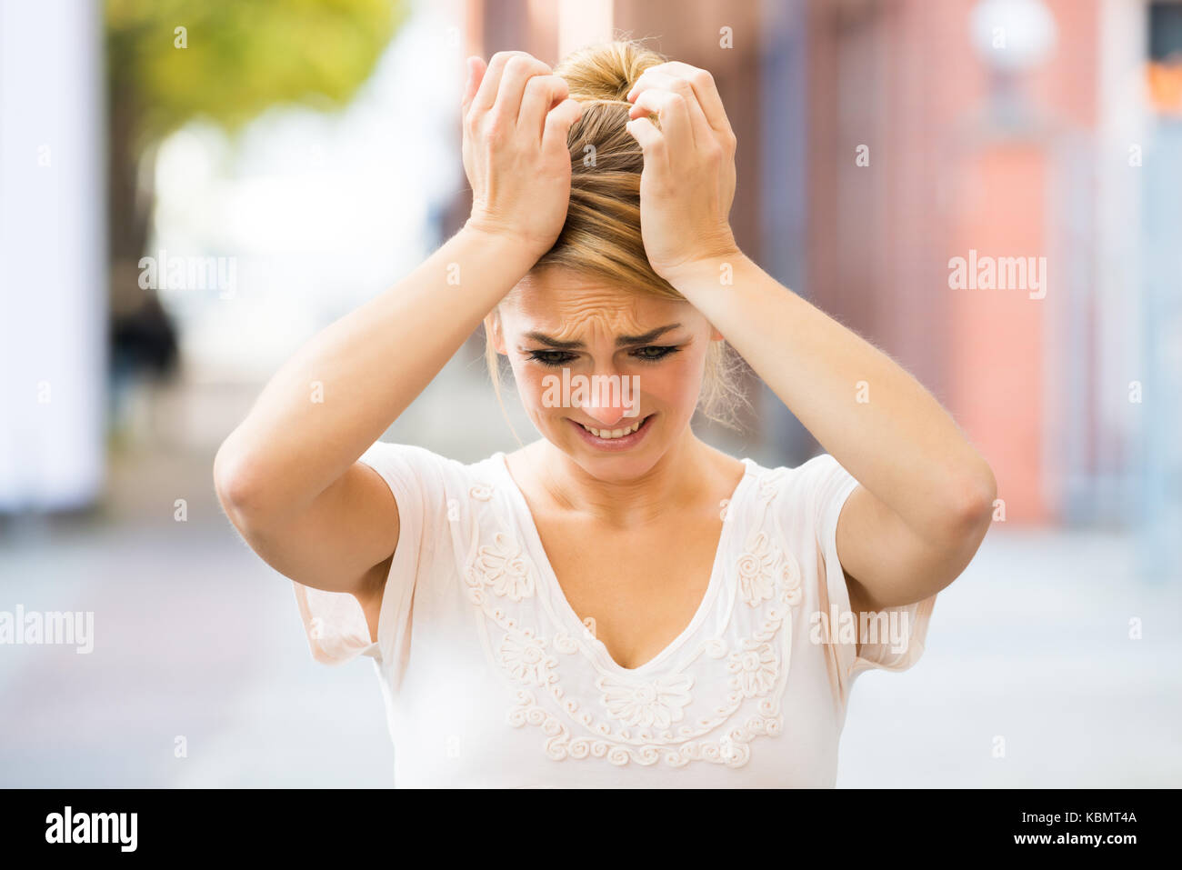 Triste giovane donna che soffre di mal di testa all'aperto Foto Stock