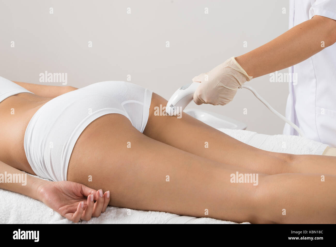 Close-up di donna sdraiata epilazione ricevente il trattamento laser sulla natica Foto Stock