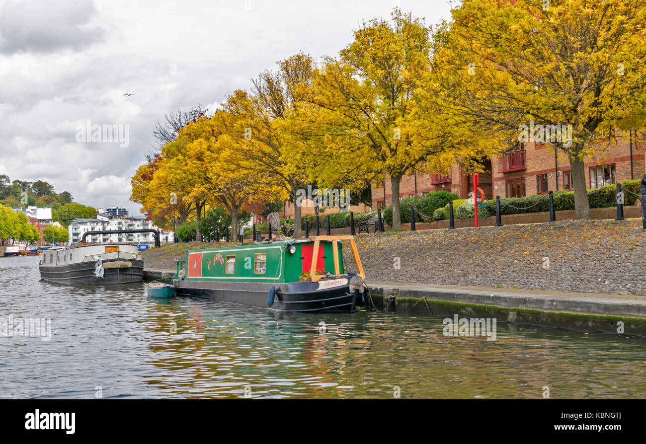 BRISTOL INGHILTERRA CENTRO CITTÀ HARBOURSIDE HOTWELLS Fiume Avon Case sul porto e alberi autunnali con houseboat ormeggiata lungo Foto Stock