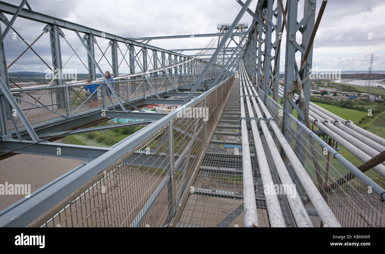 Vista verso est dal punto intermedio lungo il lato meridionale di ponte superiore passerella pedonale di Newport Transporter Bridge, che mostra i cavi di controventatura, e 2 visitatori Foto Stock