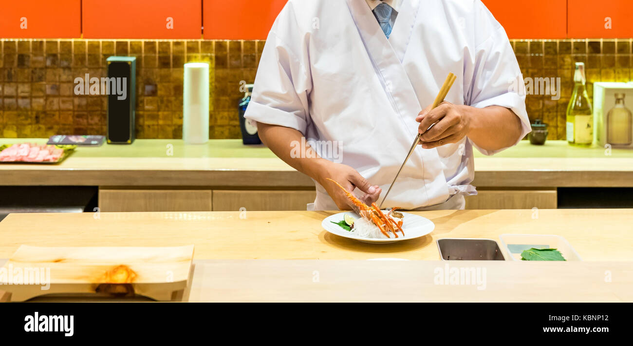 Lo chef preparazione e cottura di sashimi di aragosta Foto Stock