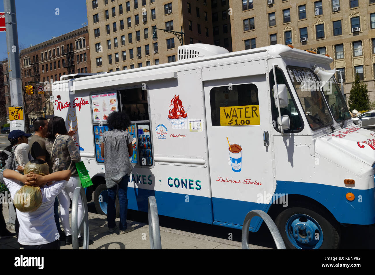 Adulti e bambini fodera fino ad acquistare da un gelato carrello in Brooklyn, New York. Foto Stock