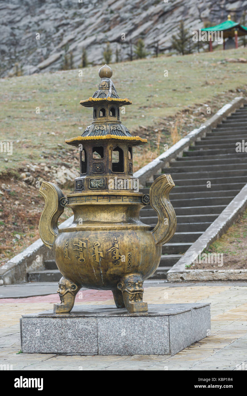 Metallo mongola statua religiosa sul piedistallo di granito con lunghi passi sullo sfondo Foto Stock