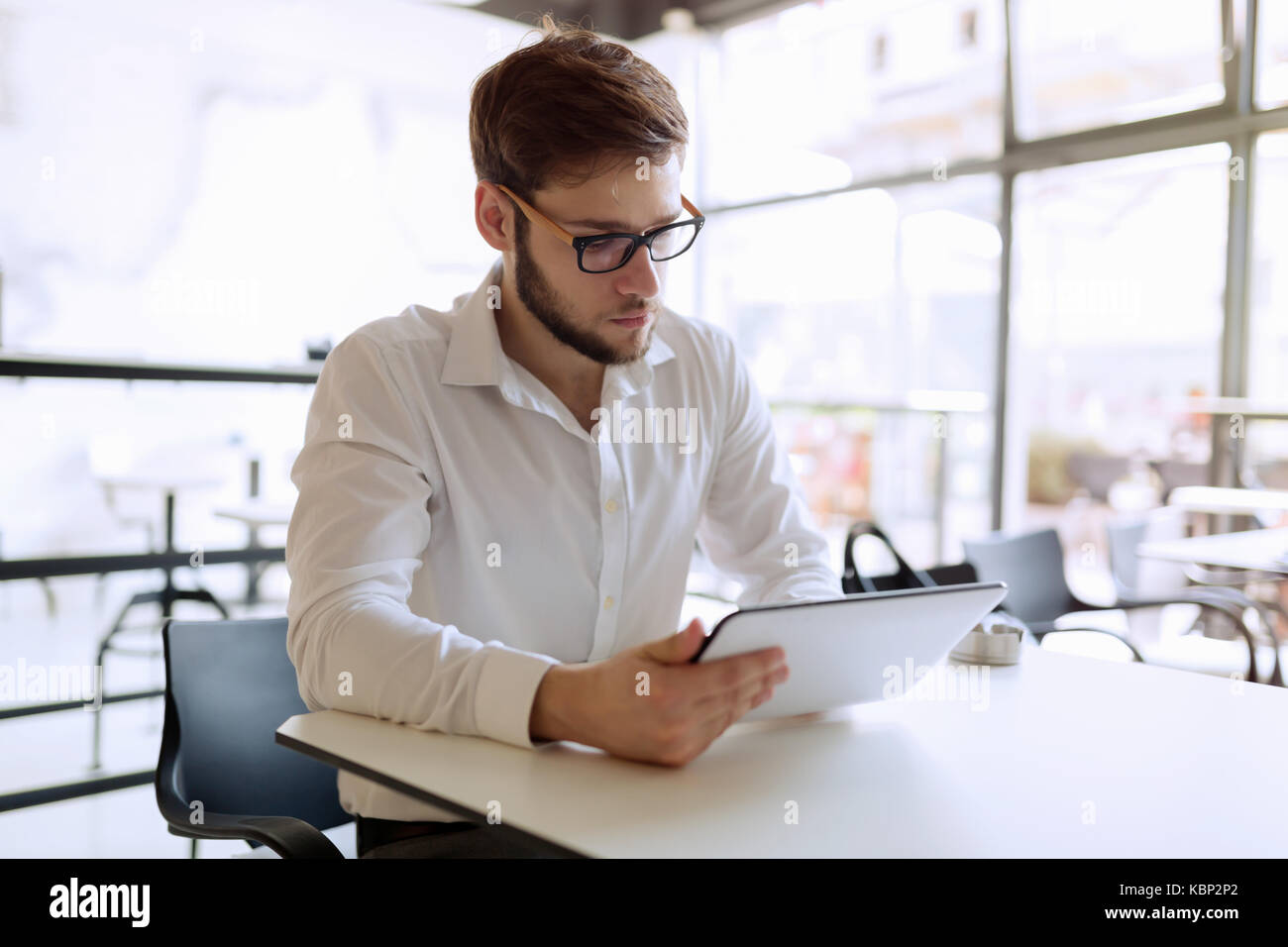 Fiducioso imprenditore occupato lavorando su tablet Foto Stock