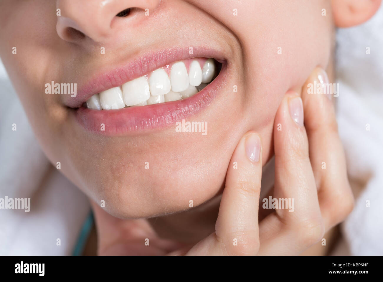 Primo piano della giovane donna che soffre di mal di denti a casa Foto Stock