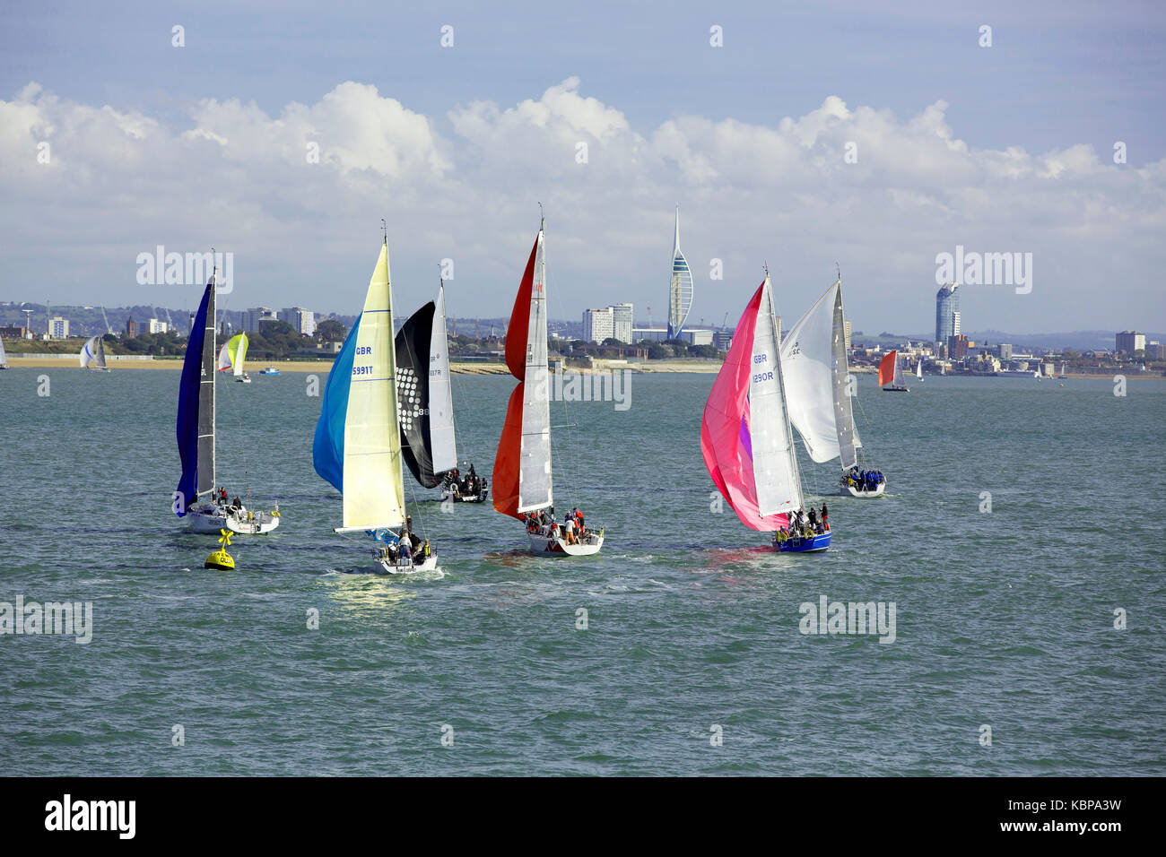 Coloratissime vele sul veloce movimento racing yachts dirigendosi verso portsmouth. Il portsmouth skyline tra cui la Spinnaker Tower in background. Foto Stock