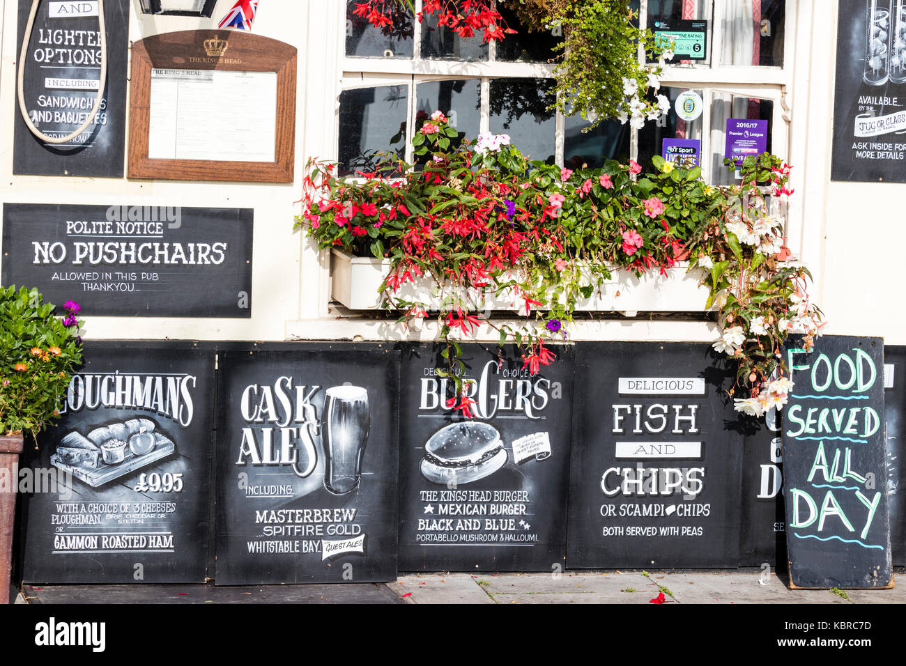 Inghilterra, trattativa. Xvii secolo King's Head Pub e Inn. Chalk boards pubblicità esterna vari cibi in vendita. Pesce e Patatine, hamburger, plowmans. Foto Stock