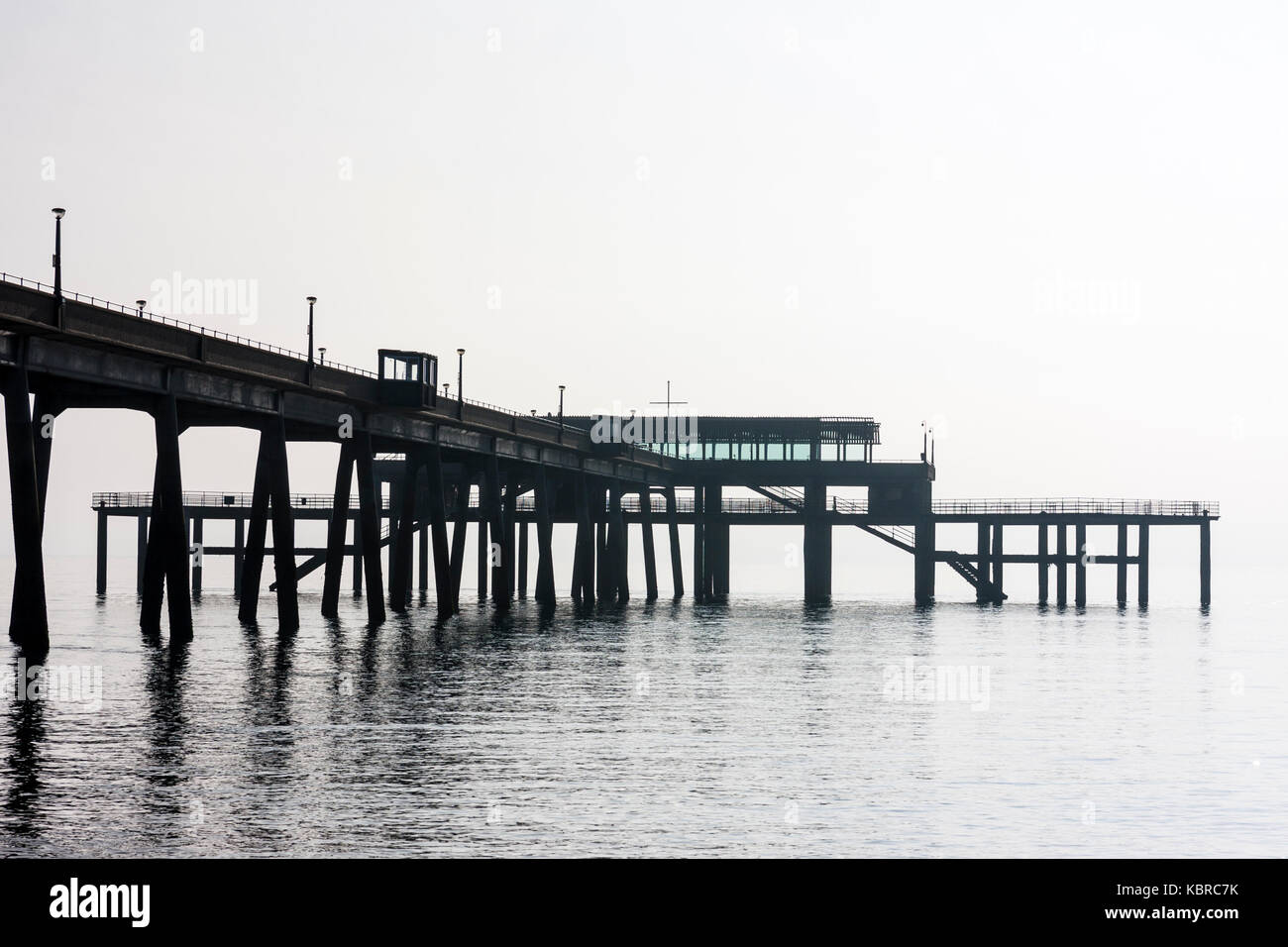 Inghilterra, trattare Pier. La mattina presto, misty luce brillante con nessun orizzonte. Il Molo Jetty andando per mare, molto calmo. Quasi in bianco e nero. Foto Stock