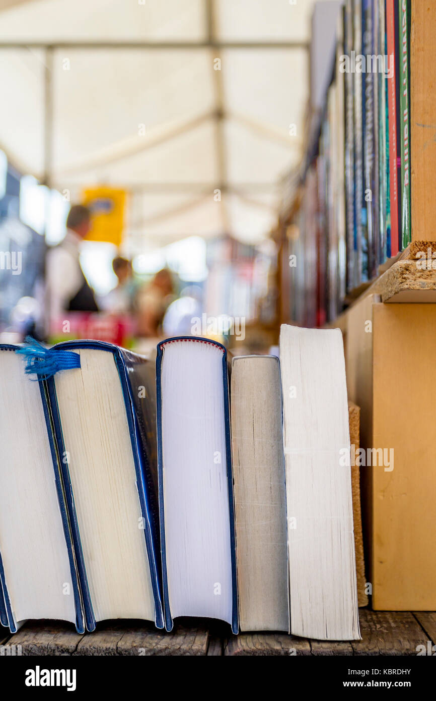 Libri di seconda mano per la vendita in un mercato del libro con le persone in background Foto Stock