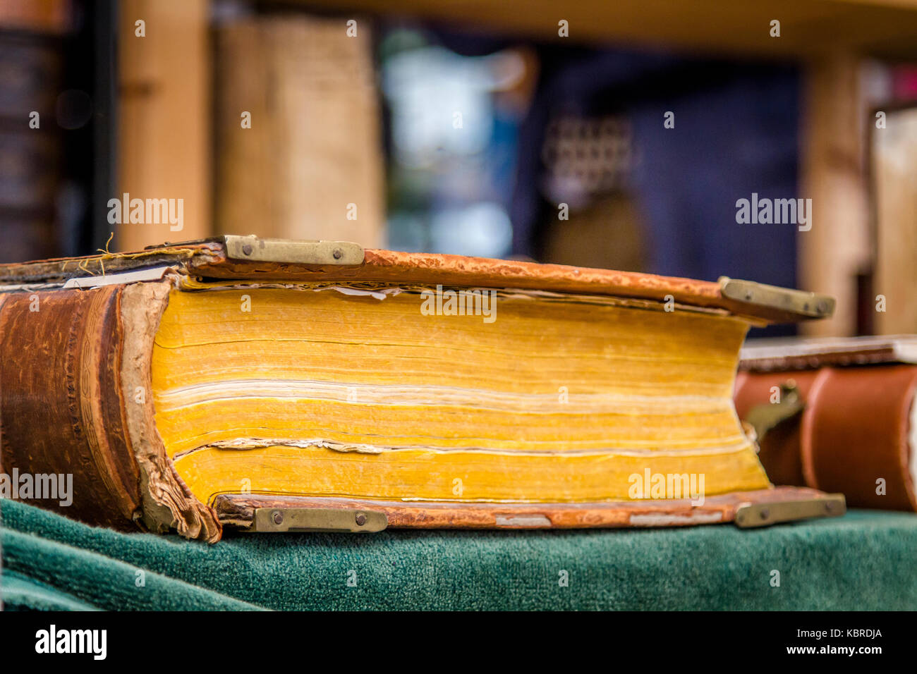 Antico libro rilegato con ingiallimento pagine giacente sul tavolo coperti da tappeti verdi Foto Stock