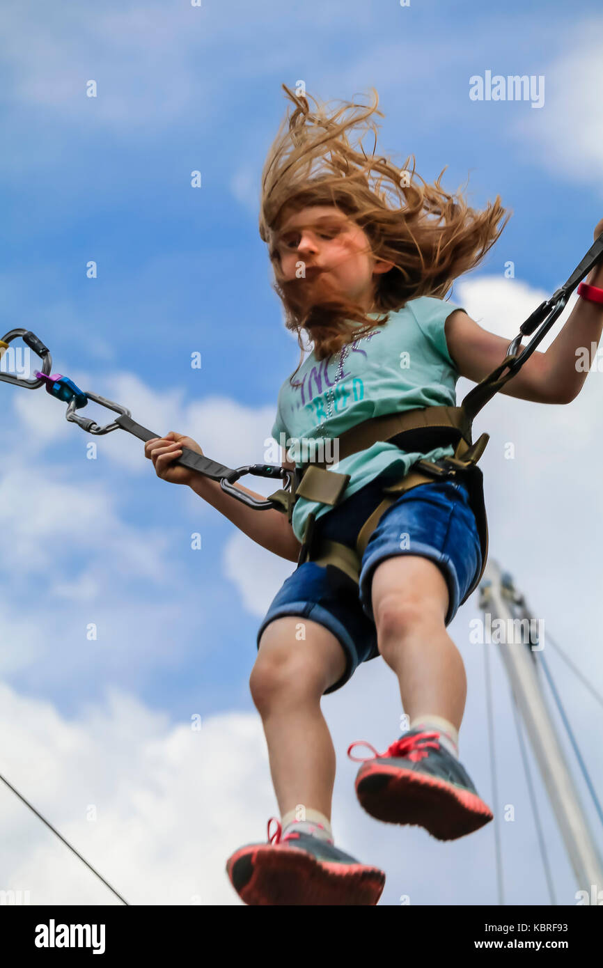 Ragazza giovane di saltare sul trampolino elastico in un parco di  divertimenti; le ragazze capelli se volare, STATI UNITI D'AMERICA Foto  stock - Alamy