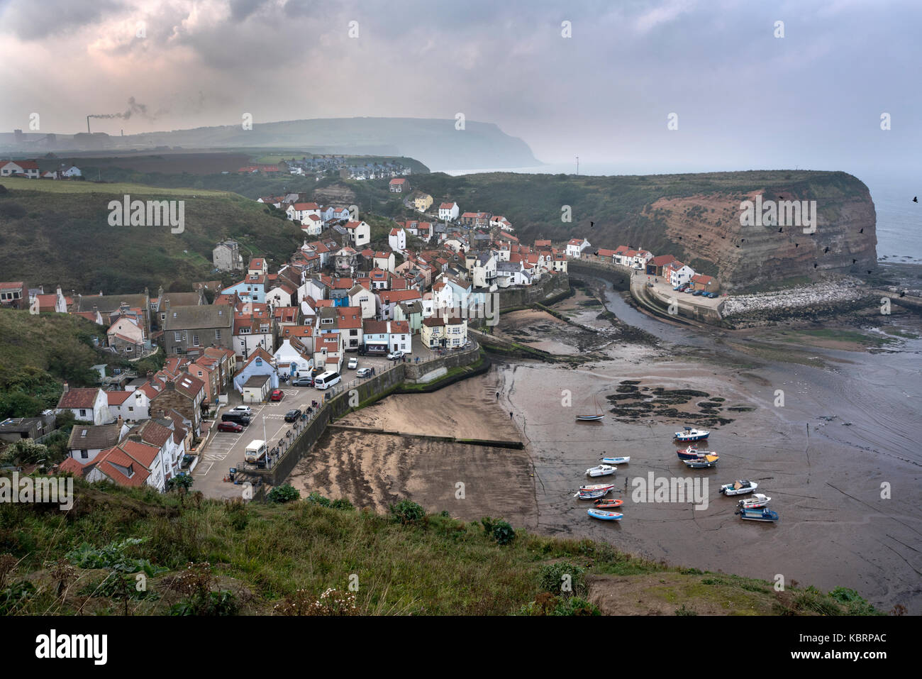 Un mare di fret scende sul villaggio costiero di Staithes, North Yorkshire, Regno Unito. Si vede dal modo di Cleveland percorso. Foto Stock